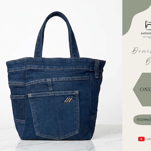 Może przedstawiać: Dżinsowa torba typu tote w kolorze niebieskim o klasycznym designie. Torba posiada przednią kieszeń i solidne uchwyty. Torba jest w jednym rozmiarze i przyjazna dla początkujących. Tekst mówi 'Denim Tote Bag'.