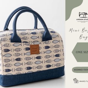 May include: A mini Boston bag featuring a cream-coloured fabric patterned with blue fish. The bag has a denim blue base, handles, and pocket trim. A small brown tag reads "Hand made". The bag is beginner friendly.