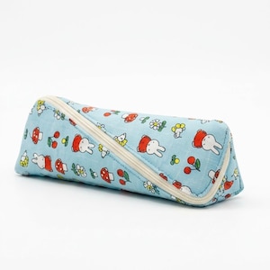May include: A light blue triangular pencil case featuring a repeating pattern of white cartoon rabbits, red mushrooms, and red cherries. The case has a cream-colored zipper that runs diagonally across the front, providing a secure closure.