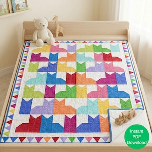 Puede incluir: Un edredón colorido con un patrón repetido de siluetas de gatos en varios colores, incluyendo rojo, naranja, amarillo, verde, azul y morado. El edredón tiene un fondo blanco y un borde con un patrón de triángulos.