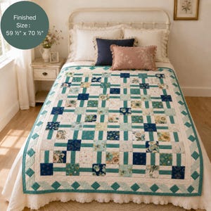 Puede incluir: Una colcha de patchwork con una cuadrícula de cuadrados con motivos florales en azul marino, verde azulado y crema, separados por bandas verde azulado. La colcha tiene un borde de rombos y mide 151,13 cm por 179,07 cm según el texto.