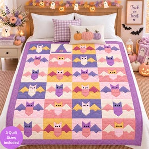 Puede incluir: Una colcha rectangular con una cuadrícula de coloridos motivos de murciélagos en tonos morado, rosa, amarillo y crema, bordeada con un ribete morado. La colcha se muestra sobre una cama con almohadas blancas y un cojín con tres calabazas.