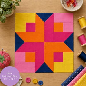 May include: A square quilt block featuring a geometric star pattern in yellow, orange, pink, and navy blue fabric. The block measures 12.5 inches by 12.5 inches. It is surrounded by sewing supplies including thread spools, buttons, and a pin cushion.