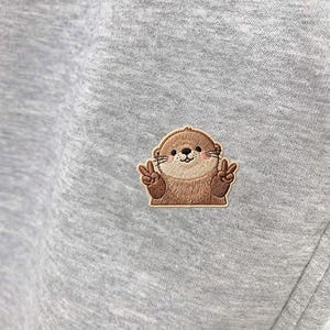 May include: A rustic wooden sign with the text "Welcome" in a handwritten style. The sign is painted white with a distressed finish, and a small, decorative heart is attached to the bottom. The background is a blurred image of a wooden surface.