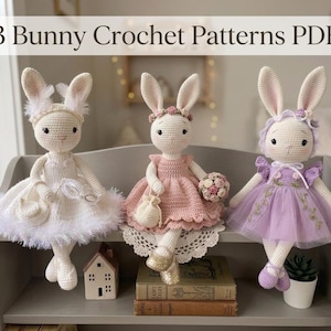 Puede incluir: Tres muñecas de conejito de ganchillo con vestidos blancos, rosas y morados, cada una con accesorios únicos. Los conejitos se exhiben en una estantería gris con libros y una casita. La imagen incluye el texto "3 Bunny Crochet Patterns PDF".