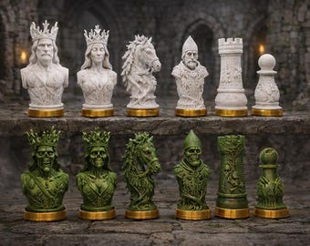 May include: A chess set featuring detailed busts of kings, queens, knights, rooks, and pawns. The top row has white pieces with gold bases, while the bottom row has green pieces with gold bases. The pieces are set on a stone surface.