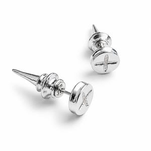 Op de afbeelding: Een paar zilverkleurige oorknopjes in de vorm van metalen schroeven. Elke oorknop heeft een platte, ronde kop met een kruisvormige inkeping en een puntig, conisch achterstuk dat de scherpe punt van een schroef nabootst.