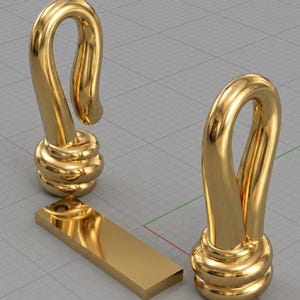 Może przedstawiać: Trzy złote metalowe haczyki i prostokątny pręt. Haczyki mają zakrzywiony, pętelkowy kształt i podstawę z ułożonych, zaokrąglonych elementów. Pręt jest płaski z otworem na jednym końcu. Obiekty znajdują się na tle kratki.