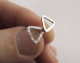 May include: A pair of silver triangle earrings with a textured finish. The earrings are connected by a small loop.