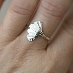 May include: A silver ring with a detailed ginkgo leaf design.