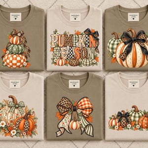 Puede incluir: Seis camisetas en beige y verde oliva con gráficos de temática otoñal. Los diseños incluyen calabazas apiladas, el texto PUMPKIN SEASON, calabazas grandes con lazos de leopardo, arreglos florales de calabaza y lazos decorativos grandes.