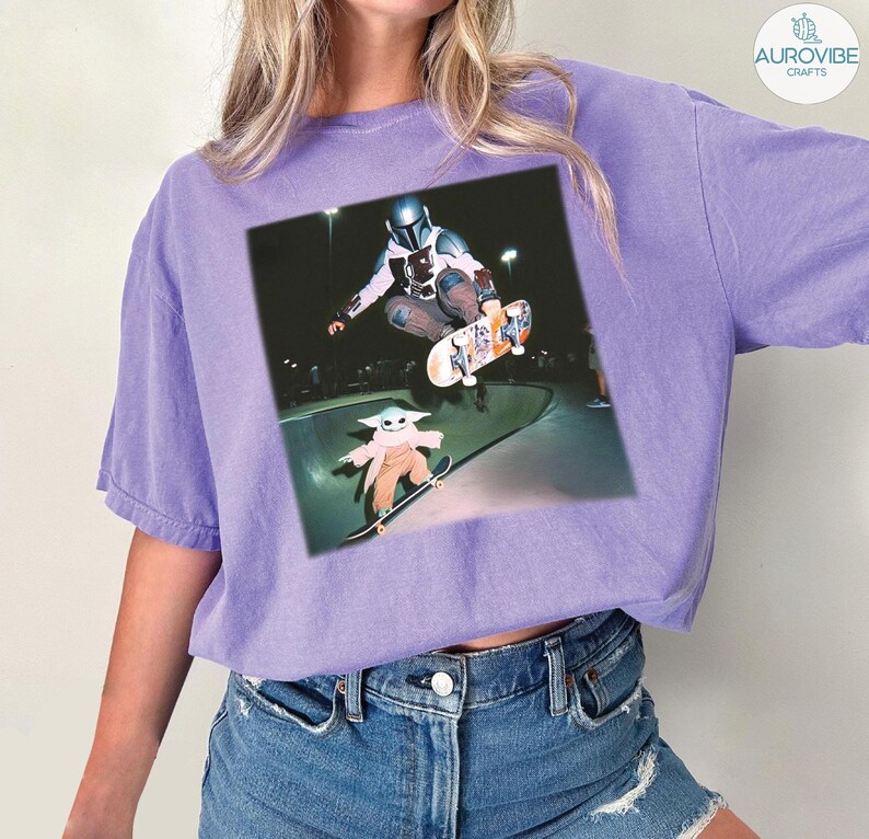 Puede incluir: Camiseta de color lila claro con un estampado gr&aacute;fico de The Mandalorian y Grogu patinando en un skate park. La imagen muestra a los personajes en el aire y en una patineta. La camiseta est&aacute; hecha de un material suave y tiene un corte holgado.