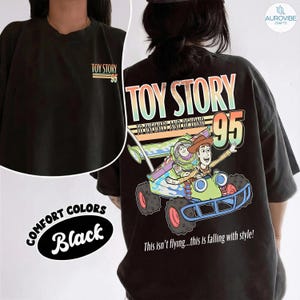 Pu&ograve; includere: T-shirt nero oversize con grafica di Toy Story con Buzz Lightyear e Woody in un'auto da corsa. La maglietta mostra "TOY STORY 95" sul davanti e sul retro, e la frase "This isn't flying...this is falling with style!"