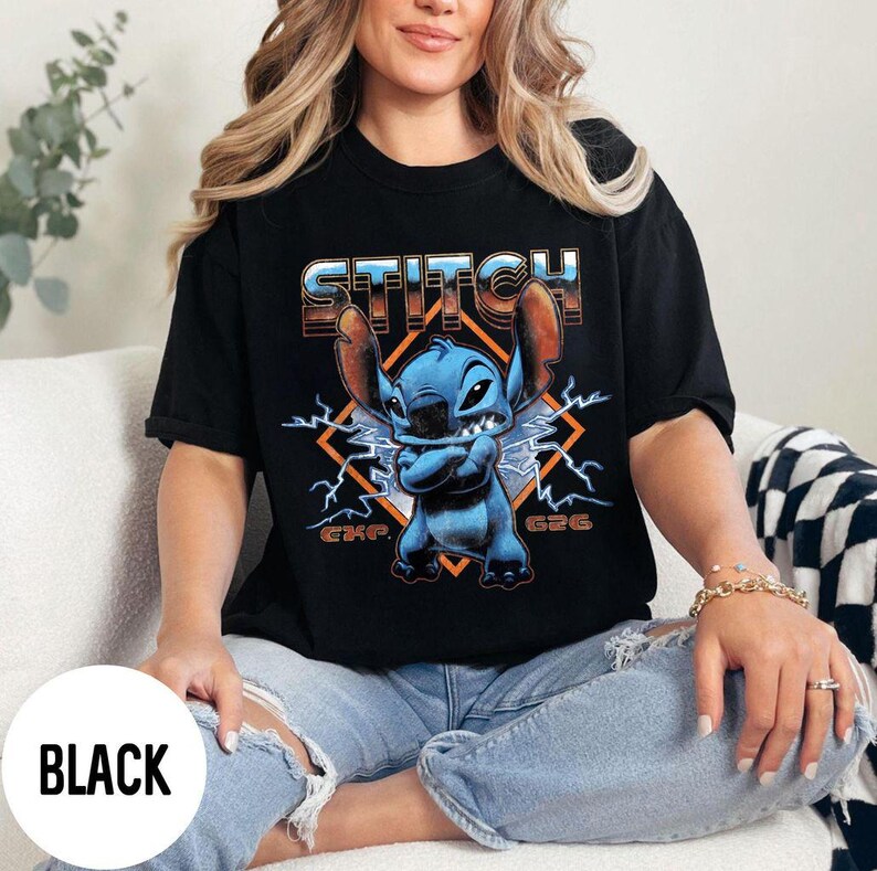 Puede incluir: Camiseta negra con un dise&ntilde;o del personaje Stitch. El dise&ntilde;o incluye la palabra "STITCH", la imagen del personaje y rayos. La camiseta es una prenda casual, adecuada para el uso diario.