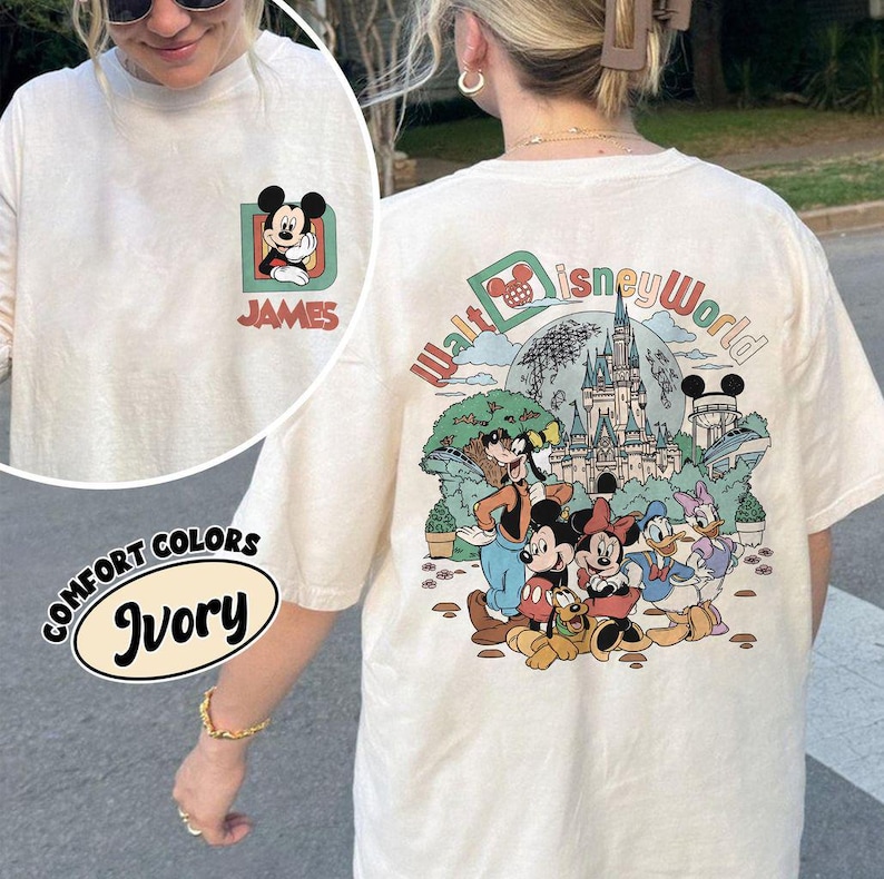 May include: Ivory-colored long-sleeve t-shirt featuring a Mickey Mouse graphic on the front with the name "JAMES" and a larger "Walt Disney World" graphic on the back. The shirt has a crew neck and is made of a soft material.