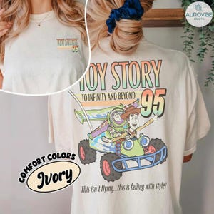 Pu&ograve; includere: T-shirt color avorio con grafica colorata "Toy Story" con Buzz Lightyear e Woody su un'auto da corsa. La maglietta include il testo "To Infinity and Beyond" e "95". Anche la frase "This isn't flying...this is falling with style!" &egrave; stampata.