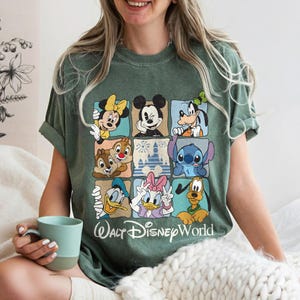 May include: Green t-shirt featuring a grid of Disney characters including Mickey Mouse, Minnie Mouse, Goofy, Donald Duck, and Daisy Duck. The shirt has the text "Walt Disney World" in a script font.