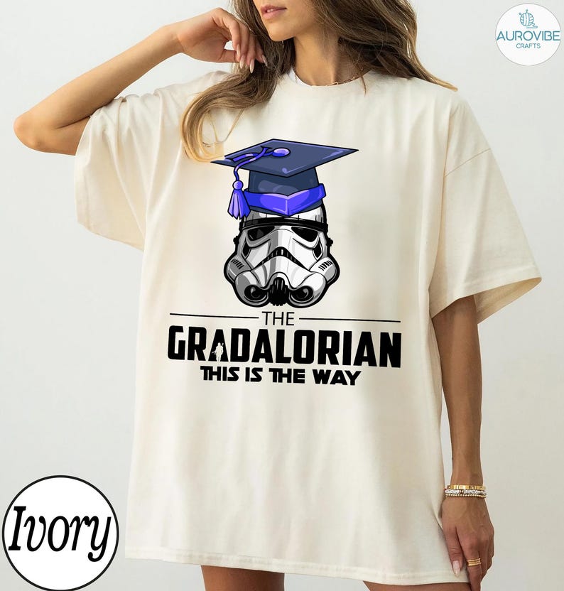 Pu&ograve; includere: T-shirt color avorio con grafica di un casco da Stormtrooper con cappello di laurea. Il testo "THE GRADALORIAN THIS IS THE WAY" &egrave; stampato in nero. La maglietta ha una vestibilit&agrave; ampia.