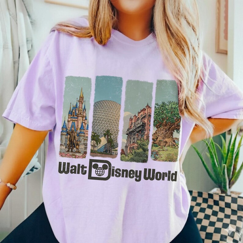Puede incluir: Una camiseta de color lila claro con un gr&aacute;fico que representa cuatro lugares emblem&aacute;ticos de Walt Disney World: el Castillo de Cenicienta, Spaceship Earth, el Hotel Hollywood Tower y el &Aacute;rbol de la Vida. El texto "Walt Disney World" est&aacute; impreso debajo.