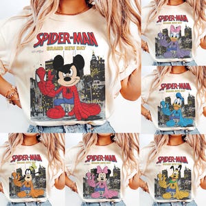 May include: Cream-colored t-shirts featuring various Disney characters in Spider-Man costumes. Each shirt has the words "SPIDER-MAN BRAND NEW DAY" printed above the character image. Characters include Mickey Mouse, Daisy Duck, Donald Duck, Goofy, and Minnie Mouse.