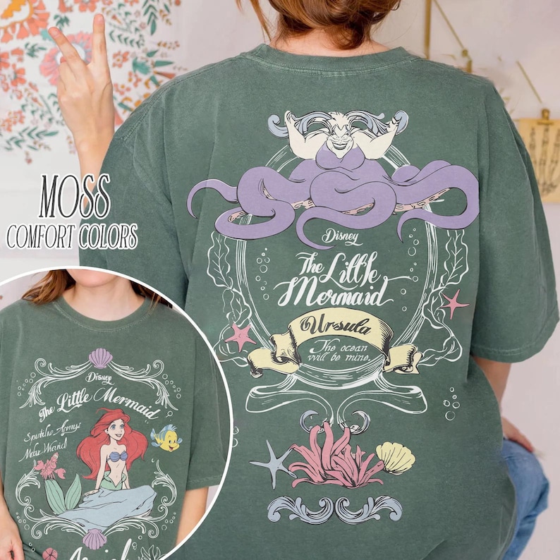 Może przedstawiać: Zielona koszulka w kolorze mchu z grafiką z Małej Syrenki Disneya. Projekt z tyłu zawiera Urszulę, tekst "The Little Mermaid" i "The ocean will be mine." Prz&oacute;d przedstawia Ariel, Florka i tekst "Spatele Agony Neue Moinch."