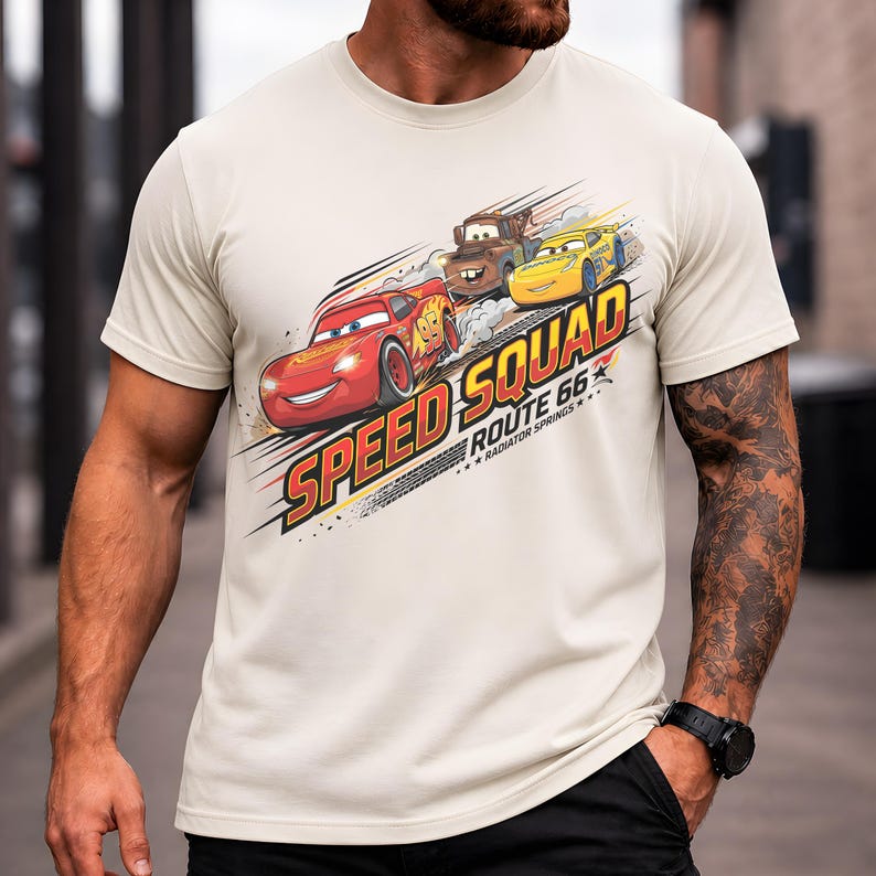 Op de afbeelding: Beige T-shirt met een afbeelding van Bliksem McQueen, Takel en een gele auto uit de film Cars. De tekst "Speed Squad Route 66 Radiator Springs" is onder de auto's gedrukt in een dynamisch ontwerp.