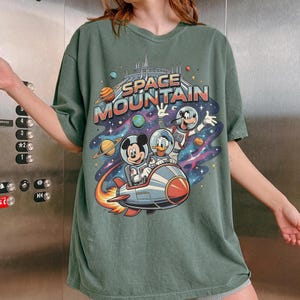 May include: A set of three ceramic mugs with a speckled, matte finish. The mugs are in shades of cream, light gray, and dark gray. Each mug has a simple, minimalist design, perfect for coffee or tea.