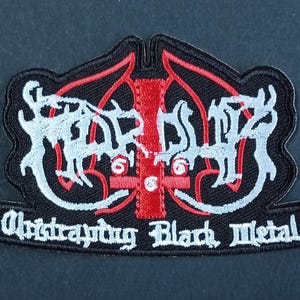 Puede incluir: Un parche bordado negro que presenta una cruz invertida roja con el número 666 en blanco, superpuesto con texto blanco estilizado que dice "Marduk" y "Arktau Eos Black Metal" en fuente gótica, todo bordeado por un grueso borde cosido negro.