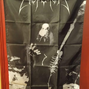Könnte beinhalten: Schwarze Flagge mit dem Bandnamen "Emperor" in weißen, gotischen Buchstaben. Die Flagge zeigt ein Schwarz-Weiß-Bild einer Figur mit weißer Maske und einem Skelettmuster. Ösen befinden sich in jeder Ecke.
