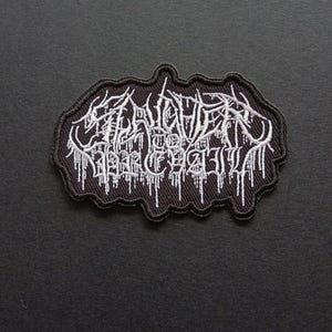 May include: A black embroidered patch featuring white text that reads Slaughter to Prevail in a stylized, jagged, and dripping font. The patch has an irregular, organic border shape and is constructed with dense thread work on a black fabric base.