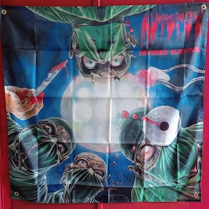 Può includere: Uno stendardo da parete quadrato in tessuto con un'illustrazione grafica di chirurghi in camice verde e mascherina che guardano verso il basso. Il testo "AUTOPSY" appare in rosso in alto a destra, con "SEVERED SURVIVAL" sotto.