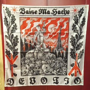 Peut inclure: Drapeau blanc avec un graphisme noir et rouge. Le drapeau porte les inscriptions "Baise Ma Hache" et "DEBOITO". L'œuvre représente un personnage avec un fusil, la Tour Eiffel et des crânes. Un feuillage noir et rouge borde le drapeau.