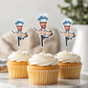 May include: Three cupcakes with white frosting, each topped with a chef-themed cake topper. The toppers feature a cartoon chef holding a spoon and a mixing bowl. The cupcakes have yellow cake and are in paper liners.