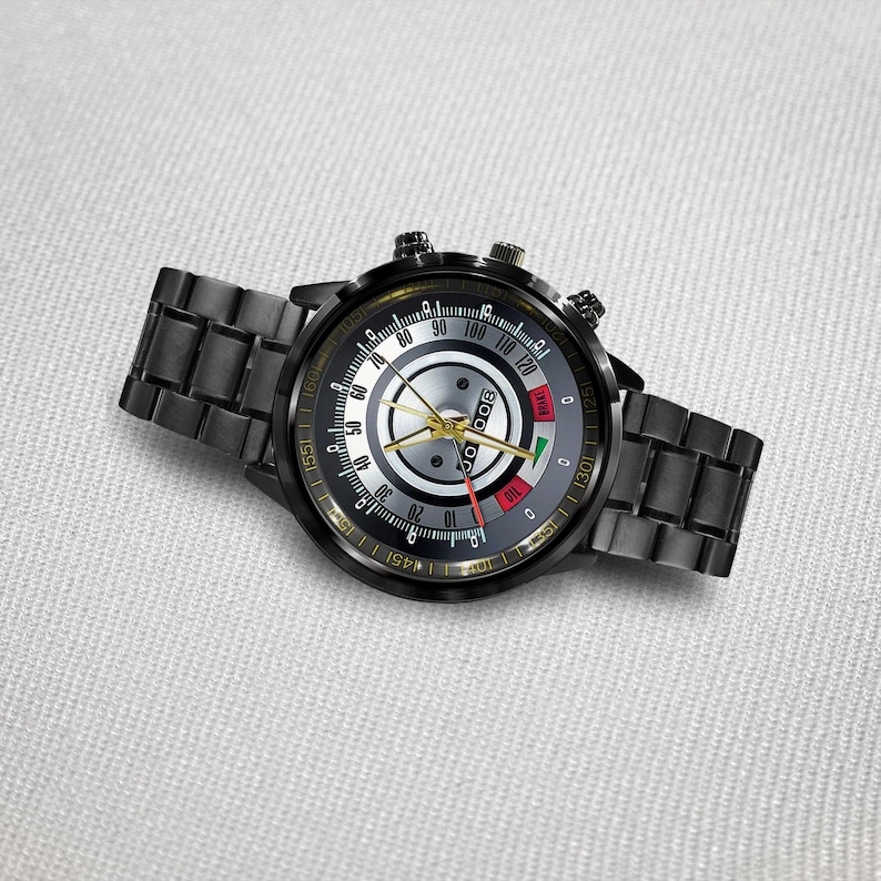 May include: Black wristwatch with a round face and a black metal band. The watch face features a silver center with black and yellow markings, and a red and green indicator. The watch has two small dials on the side.