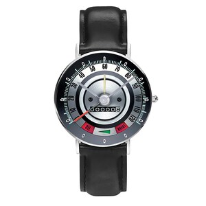 May include: A wristwatch with a black leather band and a silver-colored face designed to resemble a car's speedometer. The watch face features a gauge with numbers, a red needle, and the words "OIL" and "BRAKE".