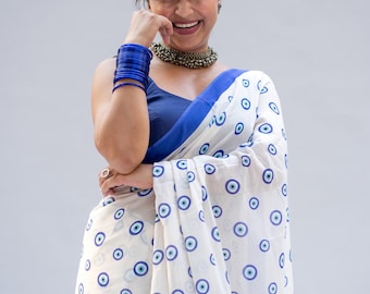 Mul Cotton mit Bluse/Nazar Andaaz ist ein verspielter weißer Baumwoll-Mul-Sari, der mit skurrilen, vom bösen Blick inspirierten Illustrationen bedeckt ist.