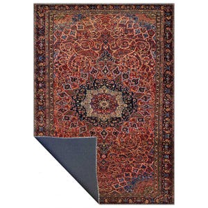 K&ouml;nnte beinhalten: Ein rechteckiger Teppich mit traditionellem persischem Design. Der Teppich hat ein tiefrotes Feld mit komplizierten floralen und geometrischen Mustern in Blau-, Gold- und Cremet&ouml;nen. Ein dunkelblauer Rand umrahmt das Design. Die Unterseite des Teppichs ist einfarbig dunkelblau.