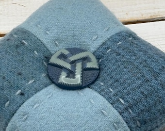 Botón de celuloide vintage con diseño de cuatro parches en color azul.