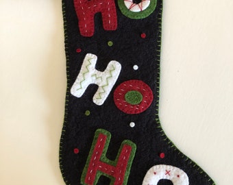 Medias navideñas con el texto "Ho Ho Ho" sobre fondo negro - Fieltro de mezcla de lana