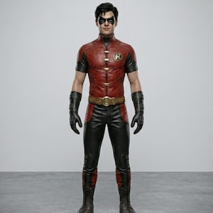 May include: A red and black costume with a gold belt buckle and the letter "R" on the chest. The costume includes a mask, gloves, and boots. The outfit is a superhero costume.