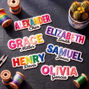 May include: Six embroidered name patches featuring colorful gradient lettering and black cursive surnames. The patches read Alexander Chen, Grace Miller, Henry Davis, Elizabeth Smith, Samuel Jones, and Olivia Garcia, surrounded by thread spools.