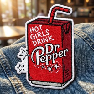 May include: A red embroidered patch shaped like a juice box with a straw. The text reads HOT GIRLS DRINK Dr Pepper in white lettering. The design includes white star outlines on the left and bottom, all bordered by a thick white stitched edge.
