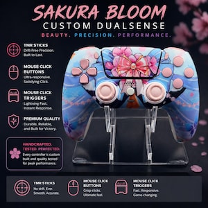 May include: A custom DualSense controller with a Sakura Bloom design. The controller has a blue and pink floral pattern with pink buttons. The text "SAKURA BLOOM" is at the top. The controller is displayed on a clear stand.