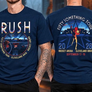 May include: A navy blue short-sleeve t-shirt featuring a graphic print on the front and back. The front displays the text RUSH, FIFTY SOMETHING TOUR, ROCKET ARENA, CLEVELAND OHIO, SEPTEMBER 17-19, 2026. The back shows a silhouette and tour details.