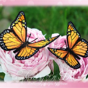 Könnte beinhalten: Zwei gestickte Monarchfalter-Patches mit orangefarbenen und schwarzen Flügeln, die auf rosa Pfingstrosenblüten ruhen. Die Schmetterlinge haben detaillierte Flügelmuster und sind vor einem verschwommenen grünen Hintergrund platziert. Das Bild enthält den Text "Embroidery By TM".