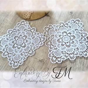 Può includere: Due centrini in pizzo bianco, ricamati con motivi floreali complessi. I centrini sono quadrati con angoli arrotondati e sono posizionati su una superficie di legno. L'immagine include anche il testo "Embroidery By TM, Embroidery designs by Teresa."