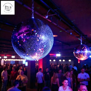 Puede incluir: Dos bolas de discoteca grandes colgando del techo, reflejando la luz sobre una multitud. Las bolas están cubiertas de pequeños cuadrados espejados. La escena está iluminada con luces moradas y rojas, creando un ambiente de fiesta.