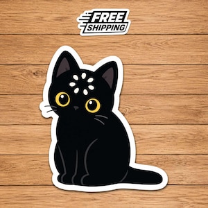 May include: A black cat sticker with large yellow eyes and a white flower-like mark on its forehead. Above the cat, a white rectangular label features the black text FREE SHIPPING. The sticker has a white border and a flat, graphic design style.