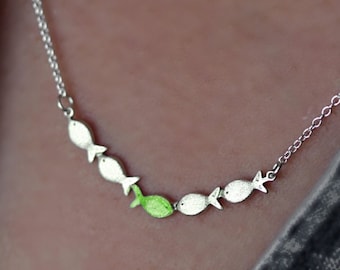 Against the current. Dainty silver necklace. Against the tide with one green fish swimming upstream. Womens necklace.