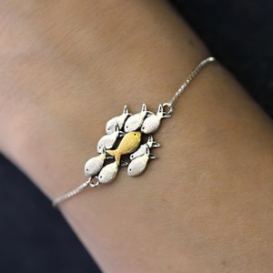 Swimming against the current silver bracelet. School of fish with one golden enameled fish swimming upstream. Unique gift for her.